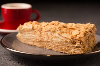 Kahve fincanında bir dilim nefis Napolyon kekiyle.