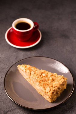 Napolyon keki yakın plan ve gri arka planda bir fincan kahve.