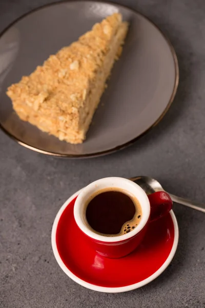 coffee expresso in a red coffee cup with a slice of delicious napoleon cake