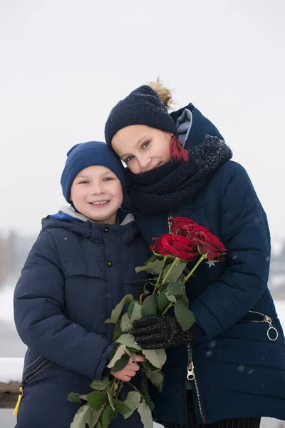 少年は少女に赤いバラを与えます — ストック写真