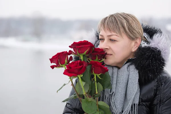 Woman with red roses outdoors in winter