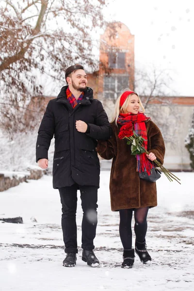 若いですハンサムな男と女の子とともにバラの花束上を歩くバレンタインデー — ストック写真