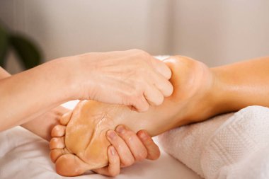 Bacaklar ve ayaklar için profesyonel rahatlatıcı masaj. Reiki nehrinde enerjik ayak temizliği, yakın plan.