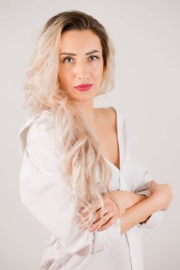 Güzel, çekici, uzun saçlı, beyaz gömlekli kadın.