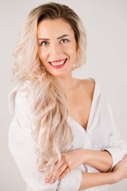 Güzel, çekici, uzun saçlı, beyaz gömlekli kadın.