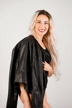 Siyah deri ceketli, uzun saçlı bir sarışının portresi.