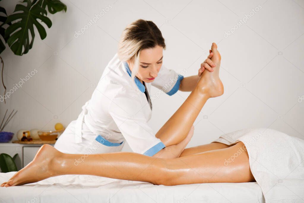 Professional relaxing massage for legs and feet. Energetic foot cleaning in a stream of Reiki, Thai massage elements for feet and legs, close-up