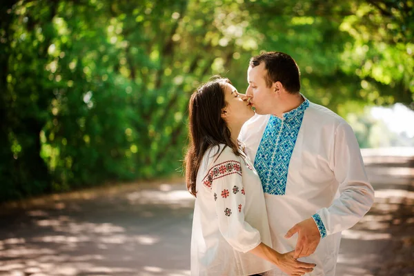 木のトンネルと道路上のウクライナの民族シャツの若いカップル — ストック写真