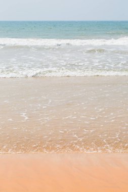 Okyanus kıyısındaki altın kumda hafif dalgalar, yaz arkaplanı