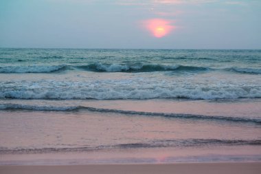 Güzel pembe gün batımı azgın okyanusun yanında, yaz arkaplanı