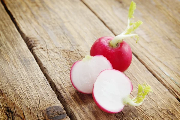 Radishes on old wooden board — Stock Photo, Image