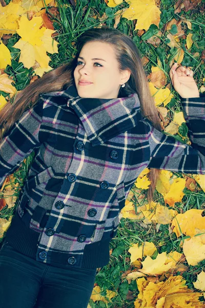Vrouw op de herfst gazon, getint — Stockfoto