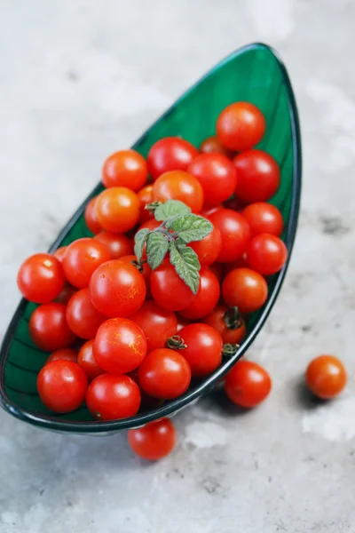 Tomatoes in a green bowl — Stock Photo, Image