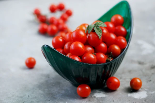 Small tomatoes in a green bowl — Stock Photo, Image