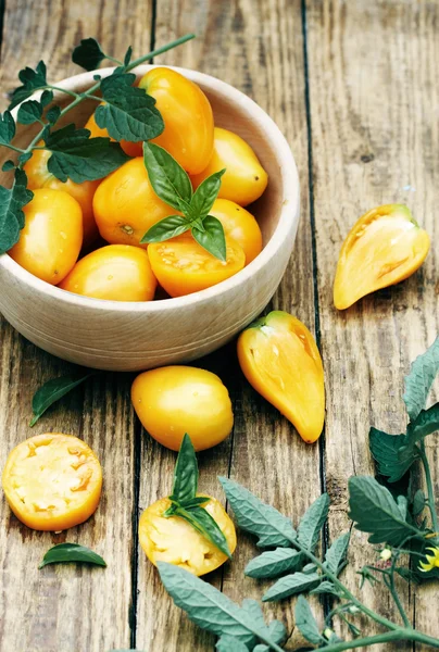 Yellow tomatoes in a wooden bowl — Stock Photo, Image