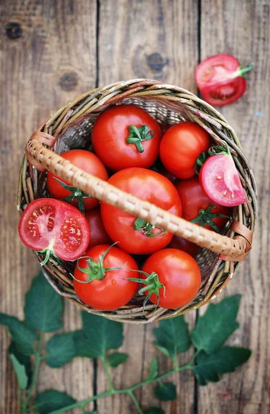 Tomates vermelhos em uma mesa de madeira — Fotografia de Stock