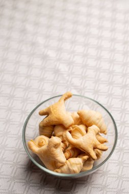 Şeffaf kruvasan ve kedi şeklinde kurabiyeler ile şeffaf kase. Ev yapımı kuru kahvaltı gevreği, çocuklar için çıtır çıtır çerez ve Cadılar Bayramı kutlaması..