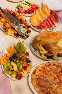 Hindiye alternatif olarak limonlu ve sebzeli fırında balık, tavuk ve pizza, Noel 'de ya da Şükran Günü aile yemeği için kırsal bir tatil masasında servis edilir..