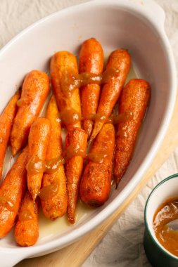 Ev yapımı karamel soslu yumuşak fırın kavrulmuş havuç sıcak ve besleyici bir yemek oluşturur. Sağlıklı aile yemekleri ve modern dikkatli yemekler için mükemmel.
