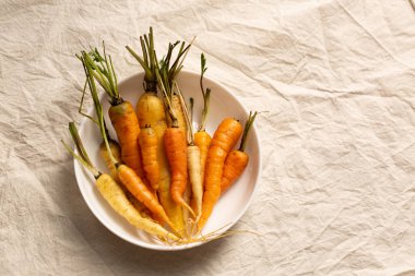 Sarı ve turuncu havuç karışımı basit bir köy kompozisyonu yaratır. Sağlıklı yaşam tarzı görseller, sıfır atık yemek pişirme ve yeni çiftlik hikayeleri için mükemmel.