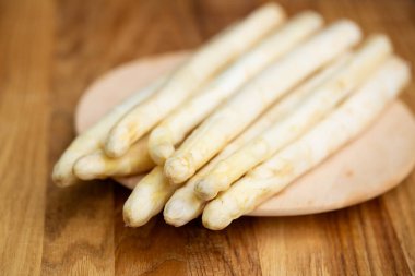 Yuvarlak tahta üzerinde taze beyaz kuşkonmaz, üst manzara, doğal ışık, mevsimsel sağlıklı sebzeler..