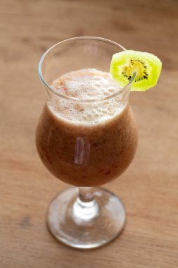 Masadaki bardaklara taze sağlıklı kivi içeceği döküldü.