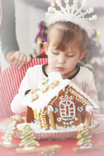 Girl decorates gingerbread house — Stock Photo, Image