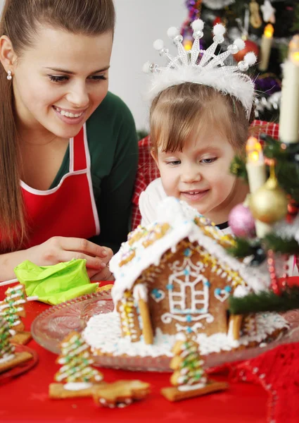 Mother and daughter and gingerbread house — Stock Photo, Image