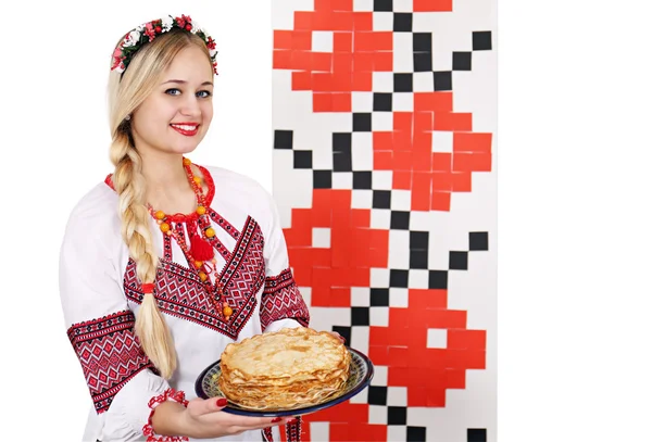 Kvinna i Folkdräkt håller en tallrik pannkakor — Stockfoto