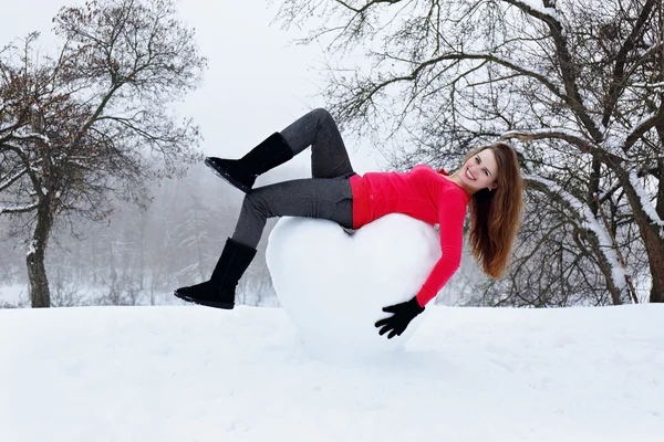 Женщина лежит на сердце снега — стоковое фото
