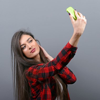 Selfie ile cep telefonu gri bac karşı alarak bir kız portresi