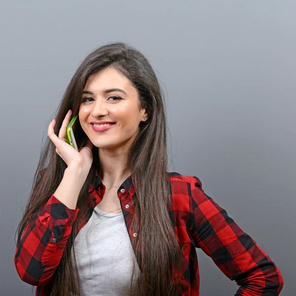 Retrato de una joven feliz hablando en un teléfono celular contra g —  Fotos de Stock