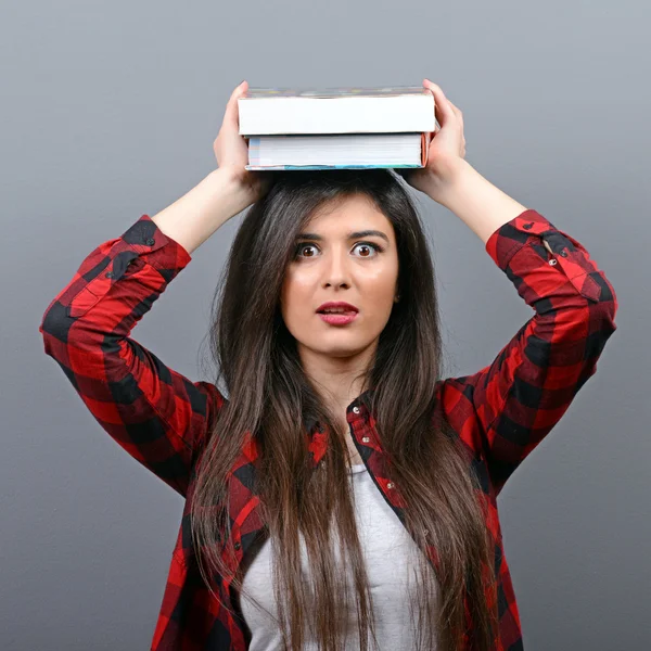 Ritratto di una giovane studentessa che tiene libri a testa contro — Foto Stock