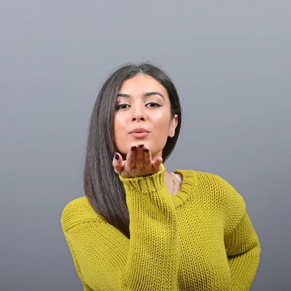 Retrato de una hermosa joven que envía un beso contra la espalda gris — Foto de Stock