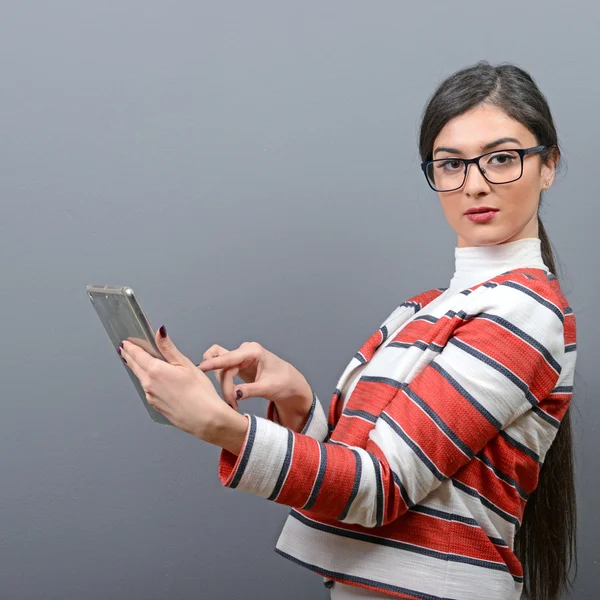 Portrait of businesswoman using tablet against gray background — Stock Photo, Image