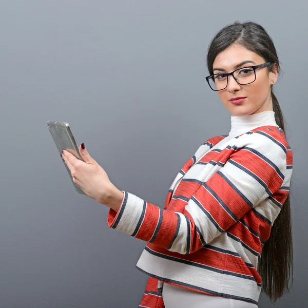 Retrato de mujer de negocios usando tableta contra fondo gris —  Fotos de Stock