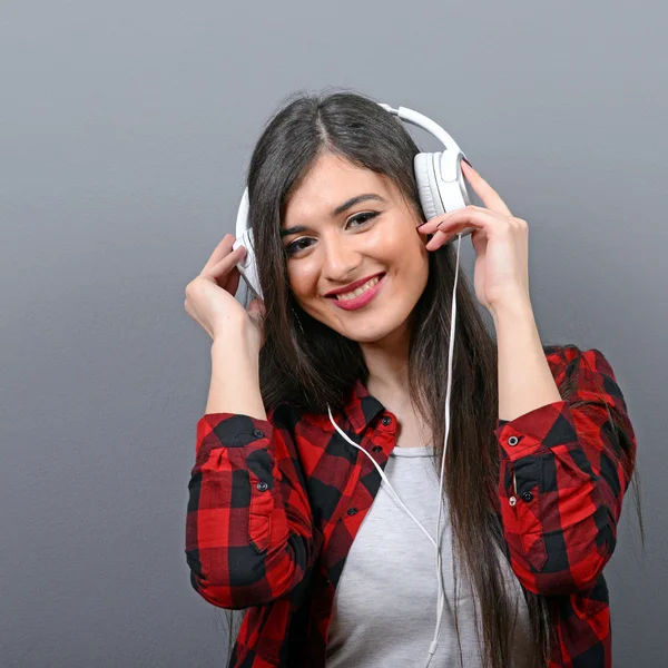 Portret van dansende stedelijke vrouw met hoofdtelefoon tegen grijze bac — Stockfoto