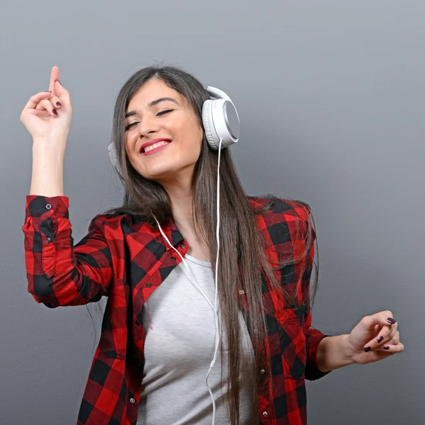 Porträt einer tanzenden Stadtfrau mit Kopfhörern gegen grauen Bac — Stockfoto