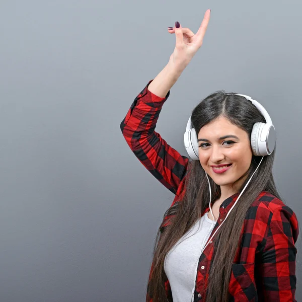 Portrait of dancing urban woman with headphones against gray bac — Stock Photo, Image
