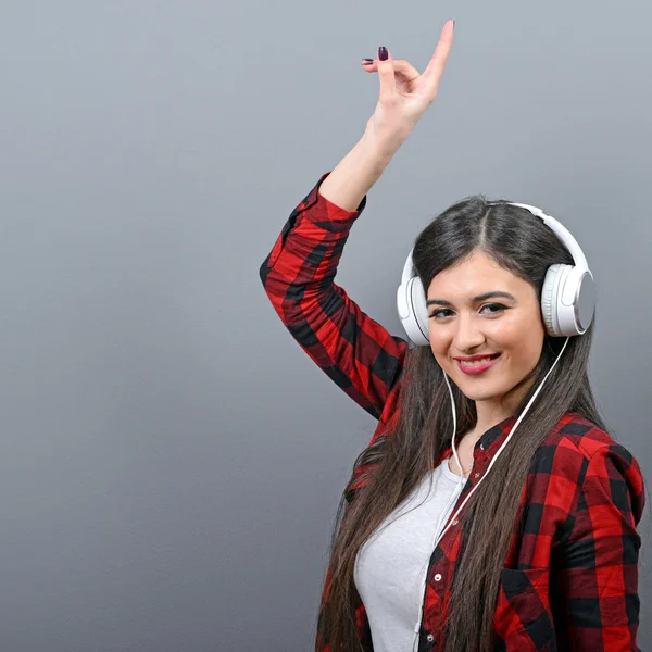 Portret van dansende stedelijke vrouw met hoofdtelefoon tegen grijze bac — Stockfoto