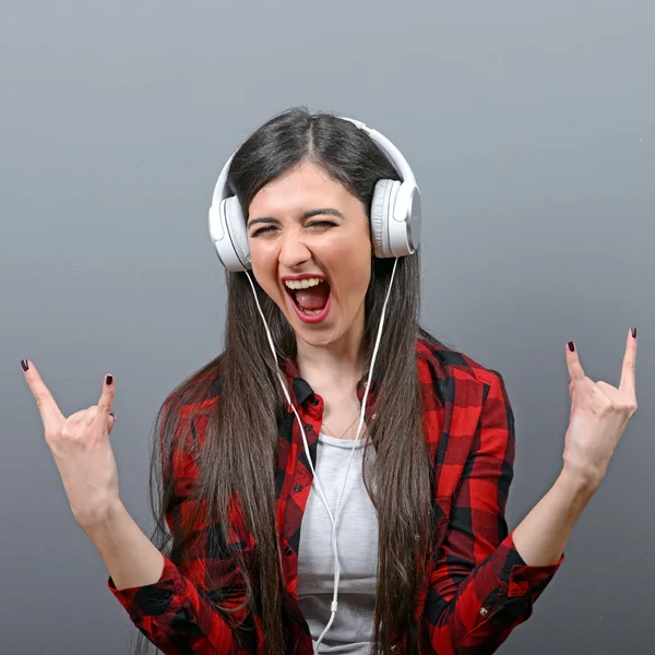 Portret van dansende stedelijke vrouw met hoofdtelefoon en rock op gest — Stockfoto