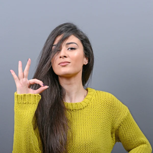Portrait of happy woman shows ok sign against gray background — Stok Foto