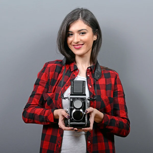 Retrato de chica hipster con cámara retro contra fondo gris — Foto de Stock