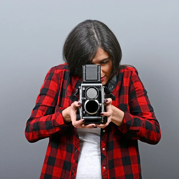 Porträt eines Hipster-Mädchens mit Retro-Kamera vor grauem Hintergrund — Stockfoto