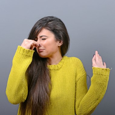 Bir şey gösterilen el ile burun kapsayan kadın portresi