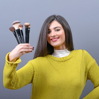 Makyaj fırçaları karşı gri adam tutan kadın portresi