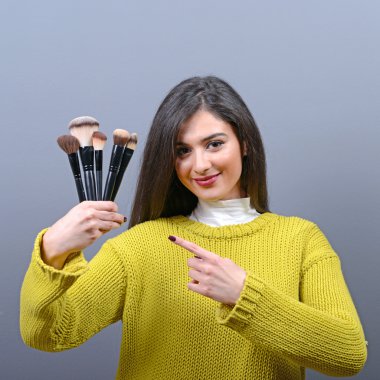 Makyaj fırçaları karşı gri adam tutan kadın portresi