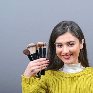 Makyaj fırçaları karşı gri adam tutan kadın portresi