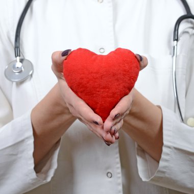 Yine kırmızı kalp tutan genç güzel kadın doktor portresi