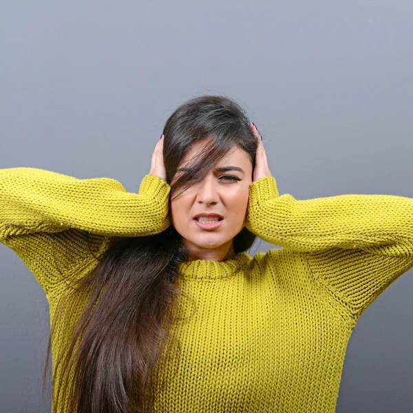 Retrato de mulher cobrindo orelhas com as mãos contra backgrou cinza — Fotografia de Stock